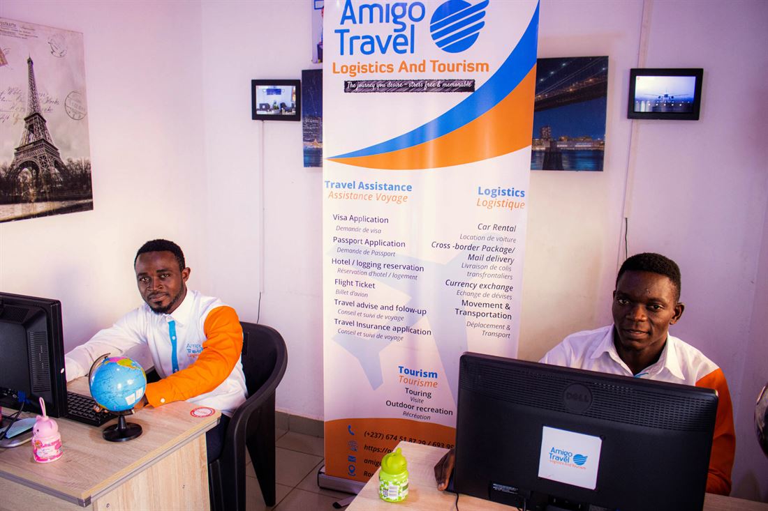 Two advisors beside the Amigo services banner